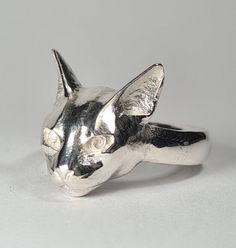 Sterling silver Abyssinian Cat ring.  Original design carved in wax then lost wax cast into solid sterling silver.  Shown in a size S, and adjustable to ring sizes J-Z6. (Half sizes are available, please select the size you want and then send us a note to let us know you want the half option). First class post included. Lost Wax Ring, Elegant Cat Design Jewelry Ring, Adjustable Cat Design Rings, Silver Cat Design Ring, Sterling Silver Jewelry With Cat Print, Wax Carving Jewelry, Nature-inspired Sterling Silver Jewelry With Lost Wax Casting, Silver Cat Ring, Abyssinian Cat