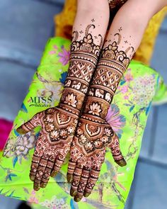 two hands with henna tattoos on them