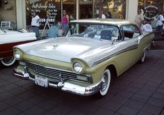 an old car parked in front of a store