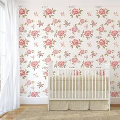 a white crib in front of a floral wallpaper