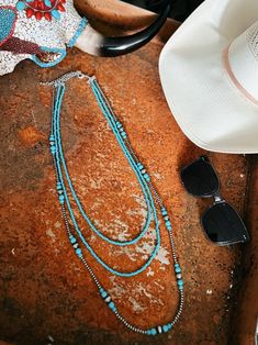 Triple Strand Turquoise And Navajo Inspired Necklace | Gussied Up Online Boutique Elevate your look with our Triple Strand Turquoise And Navajo Inspired Necklace! Handmade with tiny 4mm synthetic turquoise, this 3-strand necklace comes in varying lengths (26", 30", 36"), with a 5" extender for versatility. The clustered navajo pearl and turquoise add a touch of elegance. Nickel, lead, and chrome free for worry-free wear. Women's Western Wear, Trending Jewelry, Western Boutique, Western Wear For Women, Inspired Necklace, Southwestern Jewelry, Wedge Heel Sandals, Sterling Jewelry, Women's Wear