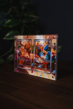 two clear cds sitting on top of a wooden table next to a potted plant