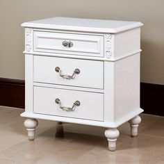 a white nightstand with two drawers on it's legs and one drawer open to the side