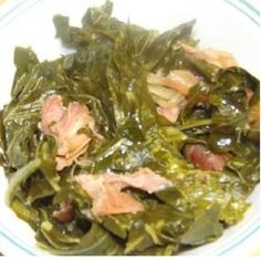 a white plate topped with greens and meat