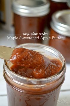 a spoon full of maple sweetened apple butter in a jar with the lid open