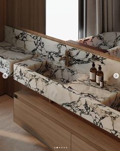 a bathroom with marble counter tops and wooden cabinets, along with two soap dispensers