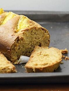 a loaf of banana bread on a baking pan with slices cut out and ready to be eaten