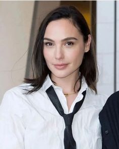 a woman wearing a white shirt and black tie