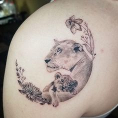 a woman with a lion and cub tattoo on her shoulder