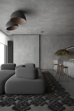 a living room filled with grey couches next to a bar