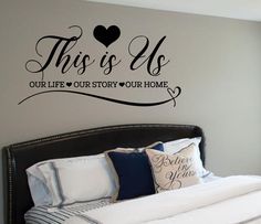 this is us bedroom wall decal with heart and name on the wall above bed