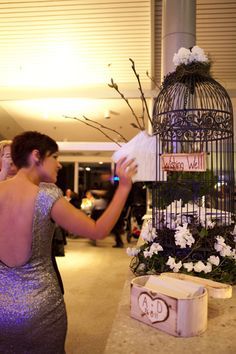 a woman in a silver dress holding a birdcage