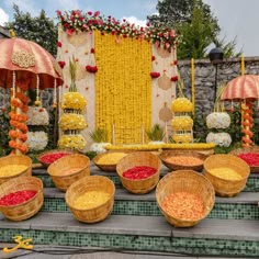 baskets filled with food sitting on top of a set of steps next to flowers and umbrellas