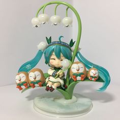 an anime figurine sitting on top of a plant with five owls around it