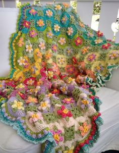 a crocheted blanket is sitting on a couch