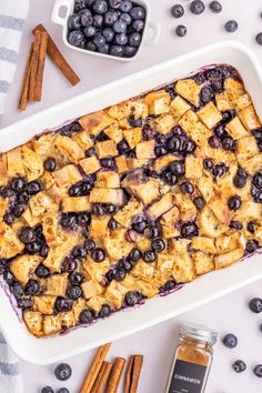 blueberry baked oatmeal in a baking dish with cinnamon sticks