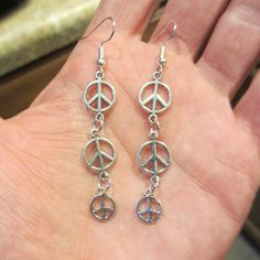 "Peace Sign Drop Earrings Pair of front hanging drop earrings -- 3 small silver tone peace sign charms linked together into a 2.5\" total drop length -- The upper Peace Sign charms are .44\" dia and the bottom one is .38\" dia. -- I used brand new hypo allergenic metal ear loops that you buy in a jewelry store or hobby shop...thanks for looking and enjoy your experience!!" Hippie Jewelry Diy, Hippy Earrings, Paz Hippie, Peace Earrings, Dangle Earrings Silver, Indie Jewelry, Hippie Girl, Hippie Earrings, Dope Jewelry