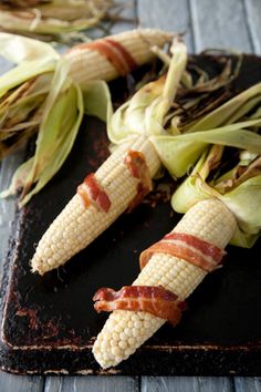 corn on the cob with bacon wrapped around it