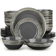 a stack of black and white plates with silver rims on top of each plate