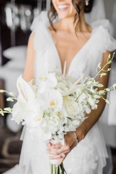 a bride holding a bouquet of white flowers