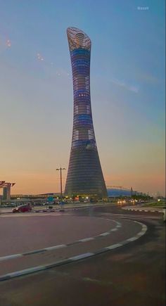 a very tall tower sitting in the middle of a parking lot next to a building