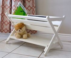 a teddy bear is sitting on a white shelf with a bookshelf in the corner