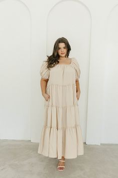 Gently feminine, the Eva Puffed Sleeve Maxi Dress is the perfect choice for the fashion-forward woman. Featuring dramatic balloon sleeves, an elastic neckline for easy wear (and easy nursing!), and tiers of ruffles for a charming yet sophisticated look, this elegant maxi dress is designed with style and comfort in mind. Its relaxed fit makes it a gorgeous choice for expecting mamas. FIT: Runs slightly oversized - very relaxed fit. Your true size will accommodate most baby bumps. MATERIAL: 91% Po Billowy Puff Sleeve Dress In Solid Color, Feminine Voluminous Puff Sleeve Dress With Balloon Sleeves, Solid Color Billowy Puff Sleeve Dress, Beige Puff Sleeve Dress With Gathered Balloon Sleeves, Feminine Billowy Puff Sleeve Dress, Modest Flowy Puff Sleeve Dress, Relaxed Fit Puff Sleeve Dress With Gathered Sleeves, Voluminous Puff Sleeve Dress For Brunch With Balloon Sleeves, Max Dress