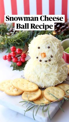 a snowman cheese ball recipe on a plate with crackers and christmas decorations in the background