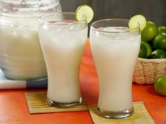 two glasses filled with milk sitting on top of a table