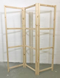 a wooden room divider in front of a white wall