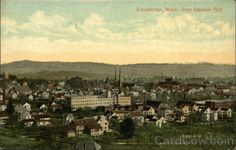 an old photo of a town with mountains in the background and clouds in the sky