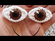 two crocheted eyeballs are shown in the palm of someone's hand