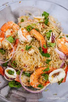 a glass bowl filled with noodles and shrimp