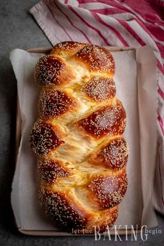 a loaf of bread sitting on top of a white tray next to a red and white towel