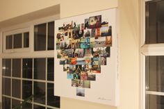 a white wall hanging on the side of a building next to a window with multiple pictures in it