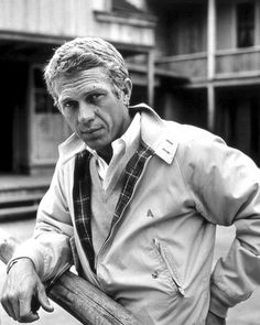 black and white photograph of man leaning on fence