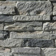 a stone wall that is made out of various types of rocks and has no mortar