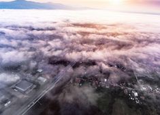 an aerial view of a city surrounded by clouds