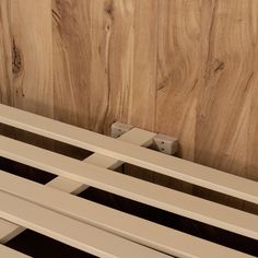 a close up of a bench against a wooden wall with wood slats on it