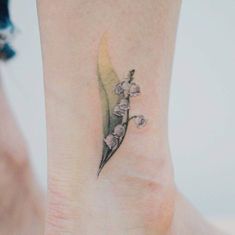 a small flower tattoo on the ankle that has lilies growing out of it's side