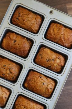 twelve muffins in a pan on a wooden table