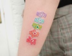 a person with a tattoo on their arm that has different colored teddy bears on it