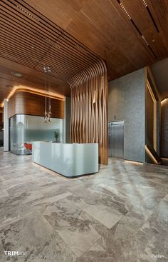 an office lobby with marble floors and wooden walls, along with a white reception counter