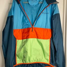 Cotopaxi Windbreaker. Unisex. Womens Xl, Men’s Large. New Without Tags. Blue Windbreaker With Pockets For Outdoor Activities, Functional Multicolor Windbreaker For Outdoor Activities, Blue Nylon Outerwear For Camping, Blue Windbreaker With Pockets For Hiking, Blue Hooded Windbreaker For Camping, Functional Blue Waterproof Windbreaker, Functional Color Block Nylon Windbreaker, Blue Hiking Windbreaker With Pockets, Blue Functional Waterproof Windbreaker