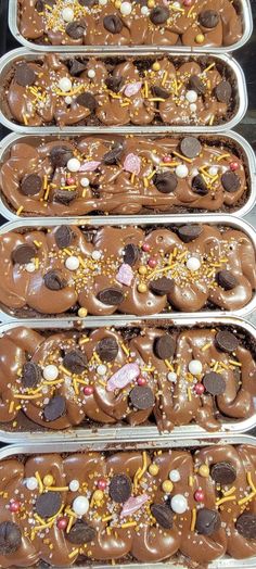 four trays filled with chocolate covered donuts