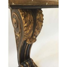 an ornate gold and black table with a lion head on it's base, against a white background