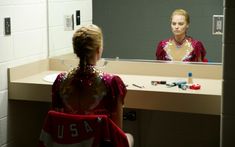 a woman standing in front of a bathroom mirror