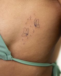 a woman's stomach with two butterflies on the side and stars in the back