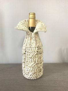 a bottle covered in yarn sitting on top of a table