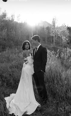 a man and woman standing next to each other in a field